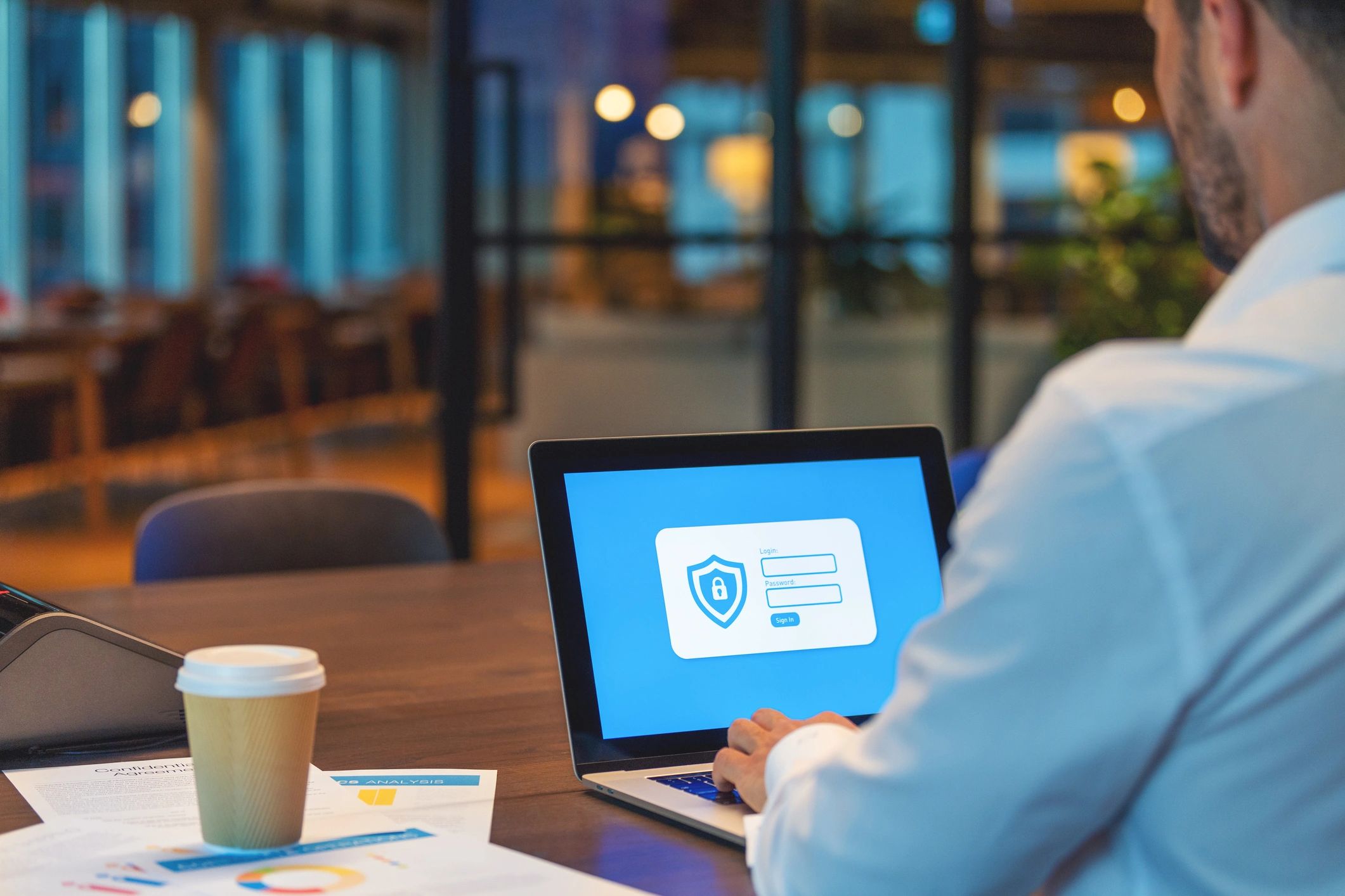 Person signing in on a laptop with security icon